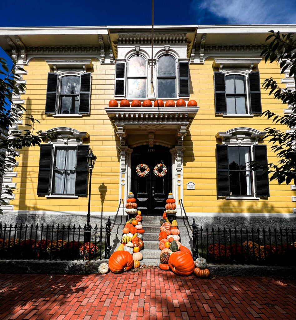 Yellow colonial home with pumpkin decorations in Salem. 